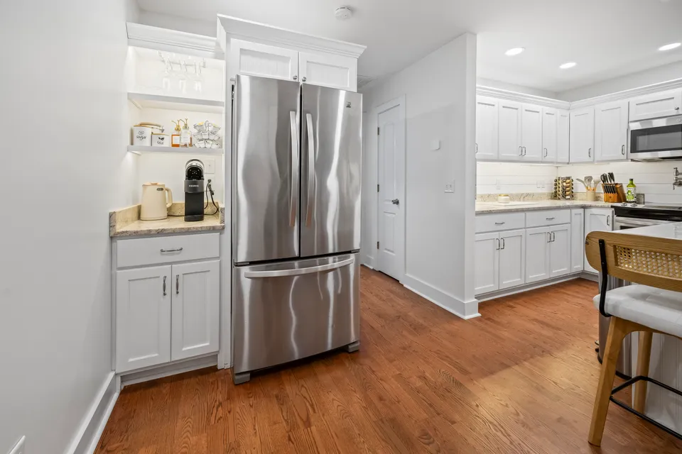 Built-in coffee station and wine glass rack nook beside the stainless refrigerator