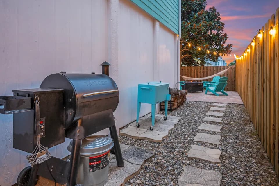 Outdoor grill and smoker station on the side patio near the hammock