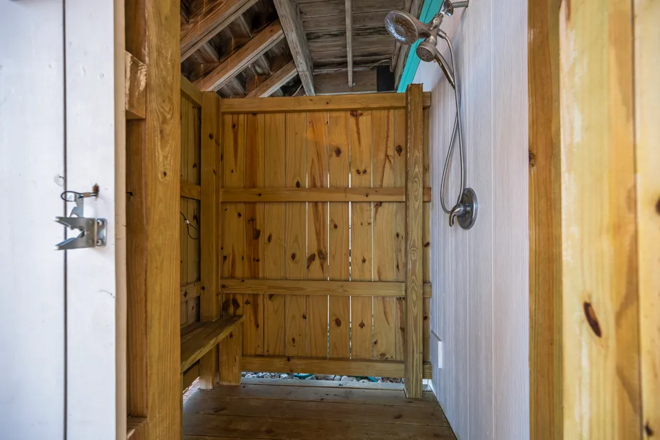 Private wood-fenced outdoor shower off the side yard