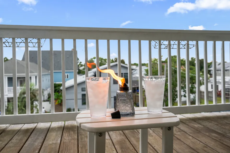 Small balcony table set with drinks overlooking the Carolina Beach neighborhood on a sunny afternoon